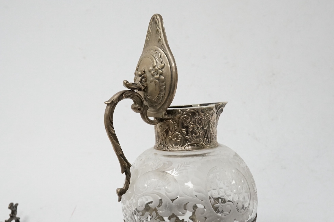 A late 19th century German pierced 800 standard white metal mounted liqueur jug, stamped Kremos, 14.4cm, a 19th century Dutch embossed 830 standard white metal trinket box and an Edwardian Hanau silver tea strainer, impo